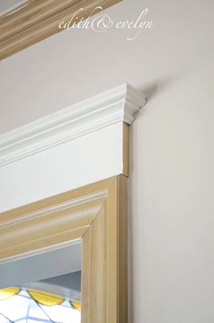 the corner of a room with a stained glass window and white molding on the wall