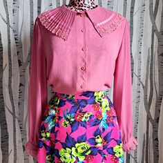 This 1970s dusky pink blouse with its sweet feminine tailoring details is a really wonderful garment. A great statement shirt is an absolute wardrobe essential and can elevate so many outfits.  The neckline is a theatrical pleated, frill collar edged in pink lace. The sleeves are loose and flowing with buttoned cuffs edged in machting lace frills.  It's in fantastic vintage condition with no stains, tears or repairs. One or two very minor pulls but nothing major.  Best fit is a modern UK size 14 Chic Pink Blouse With Lace Trim, Pink Long Sleeve Blouse With Lace Collar, Feminine Fitted Blouse With Collared Neckline, Pink Lace Collar Top For Spring, Spring Pink Top With Lace Collar, Feminine Fitted Collared Blouse, Feminine Fitted Blouse With Collar, Pink Peter Pan Collar Top For Spring, Feminine Pink Collared Top