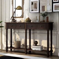 a living room scene with focus on the console table and pictures hanging on the wall