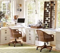 a home office with wicker chairs and white desks in front of large windows