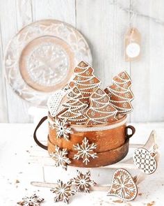 some cookies are sitting in a bowl on a table next to other cookie cutters