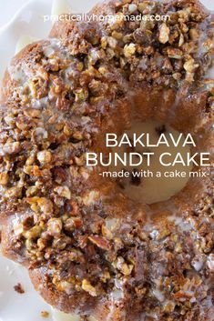 a bundt cake with walnuts and icing on a white plate that says bakalava bundt cake made with a cake mix