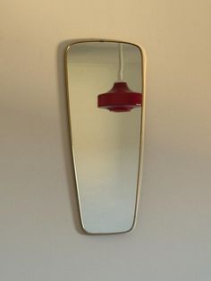 a red light hanging from the side of a mirror