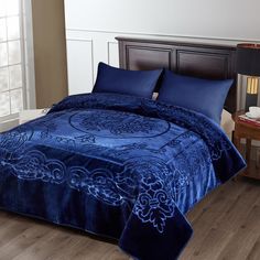 a bed with blue comforters and pillows in a room