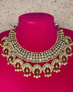 Celebrate your special occasion with this unique gold necklace that is sure to grab everyone's attention. The necklace comes with matching earrings and is in a gold finish with kundan work to accentuate the look. The pearls add an elegant touch to the set and it can also be worn alone for a statement look. 22k Gold Cutdana Bridal Earrings For Wedding, 22k Gold Cutdana Bridal Earrings, Ceremonial Gold Kundan Necklace Hand Set, 22k Gold Meenakari Bridal Earrings For Wedding, Gold Hand-set Kundan Necklace For Celebration, Gold Hand Set Kundan Necklace For Celebration, Gold Bridal Necklace With Stone Work For Festive Occasions, Yellow Gold Cutdana Bridal Earrings For Wedding, Heavy Yellow Gold Bridal Earrings For Wedding