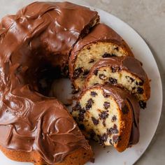 a chocolate marbled bundt cake on a white plate with one slice cut out