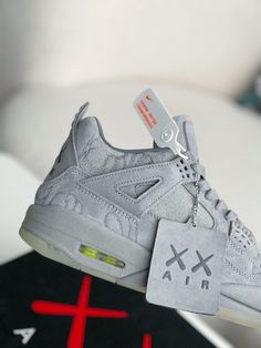 Channel the iconic KAWS x Air Jordan 4 with these inspired sneakers. They feature the same cool grey suede upper, complete with the distinctive "XX" pattern. Meticulous attention to detail ensures a look and feel that rivals the original, at a fraction of the price. Experience the legendary style and comfort of the coveted Kaws Jordan 4. Gray High-top Sneakers With Perforations For Streetwear, Designer Gray Lace-up Sneakers, Fall Winter Jacket, Jordan 4 Retro, Air Jordan 4, Air Jordan 4 Retro, Loafer Sneakers, Bottega Veneta Shoulder Bag, Grey Suede