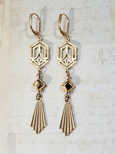 These modern Deco earrings are a great example of classic 1920s style. They feature Art Deco style brass connectors, vintage black beads, and brass fan shaped charms.The brass connectors and charms have a textured front and a back that is the hollow reverse of the front. (SEE 2nd PHOTO)They are extremely lightweight and comfortable to wear.The earrings measure 2 3/4 inches long from the top of the ear wires to the bottom of the pendants.Perfect for everyday or evening.ABOUT THIS COLLECTIONWhat a Green And Gold Art Deco, Green And Gold Art, Flapper Jewelry, Art Deco Jewelry 1920s, Black And Gold Art Deco, 1920s Earrings, October Jewelry, Gold Art Deco Earrings, Assemblage Earrings