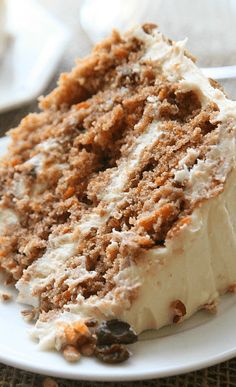 a close up of a slice of cake on a plate with cream cheese frosting