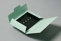 an origami box with two arrows inside on a gray surface, open to reveal the contents