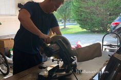 a man using a circular saw to cut wood with a mitt on a workbench