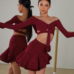 two women in red dresses standing next to each other with their hands on the hips