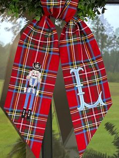 a red plaid door hanger with a monogrammed anchor and man on it