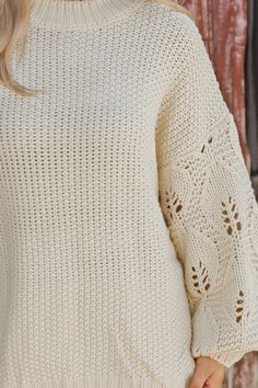 This Crochet Sleeve Pullover Sweater in Cream offers a chic blend of texture and style! Featuring long balloon sleeves with intricate crochet detailing, this sweater adds a unique flair to any outfit. It has a round neckline with ribbed detailing at the neckline, cuffs, and hem, enhancing its cozy feel. Designed with an oversized fit, it's perfect for layering and everyday comfort. Style with jeans, ankle booties, and a wide brim hat for an elevated chic outfit. Chic Pointelle Knit Cropped Sweater With Long Sleeves, Chic Cropped Sweater With Pointelle Knit And Long Sleeves, Chic Long Sleeve Pointelle Knit Cropped Sweater, Chic Long Sleeve Pointelle Cropped Sweater, Spring Sweater With Balloon Sleeves, Cream Long Sleeve Pointelle Knit Sweater, Winter Pointelle Knit Sweater With Puff Sleeves, Knit Lantern Sleeve Sweater For Spring, Fall Knit Sweater With Balloon Sleeves