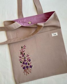 a tote bag with embroidered flowers on it