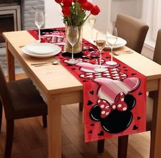 a minnie mouse table runner on a dining room table with red flowers in a vase