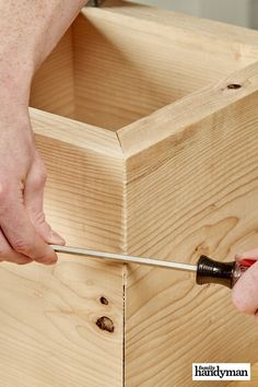 a person using a screwdriver to attach the top of a piece of wood