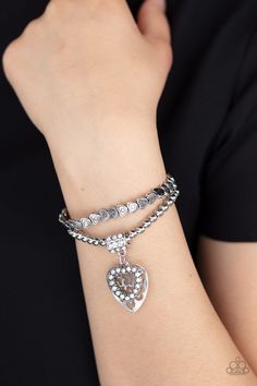 THINK WITH YOUR HEART - WHITE Brushed in an antiqued finish, classic silver beads and dainty silver heart beads are threaded along stretchy bands around the wrist, creating an adorable duo. Infused with a white rhinestone encrusted fitting, a white rhinestone encrusted heart frame and airy silver heart charm swings from the wrist for a whimsical finish. Sold as one pair of bracelets. P9RE-WTXX-335XX ORDERED 5 AUG 20 Bracelets Trendy, Silver Heart Bracelet, White Bracelet, White Bracelets, Heart Frame, Paparazzi Accessories, Stretchy Bracelets, White Rhinestone, Paparazzi Jewelry