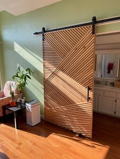 an open sliding door in a living room next to a chair and table with a potted plant on it