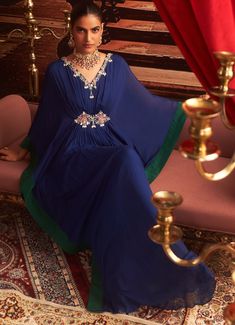 Make a statement at your next Sangeet or cocktail party in this stunning Electric Blue Chiffon Kaftan. With its exquisite embroidery along the neckline and sleeves, this Indo-Western draped kaftan offers the perfect blend of comfort and style for wedding guests. The flowing chiffon fabric drapes beautifully, creating a luxurious silhouette that's ideal for festive occasions. Whether it's a Sangeet or a cocktail event, this kaftan ensures you exude elegance. Composition : Kaftan - Chiffon & Lining - Satin Care: Dry Clean Only and Vacuum Storage This product can be customized for sleeves, blouse length and neckline Delivery : 2-4 weeks as the product is hand crafted. Check Size Guide or choose MySize for free customisation (All Sizes above XL can be made at 15% additional cost) For more info Draped Kaftan, Style For Wedding, Chiffon Kaftan, Vacuum Storage, Indian Wedding Wear, Embroidered Chiffon, Sleeves Blouse, Cocktail Event, Indo Western