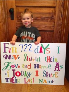 a young boy holding up a sign that says for 72 days i have shared their love and home as today i share their last name