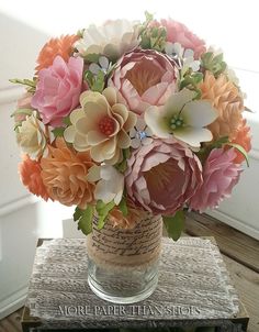 a vase filled with lots of flowers on top of a table