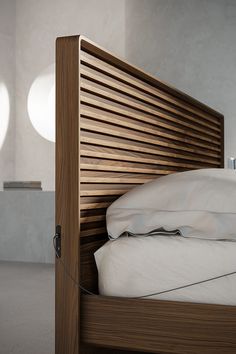 a wooden bed frame with white sheets and pillows