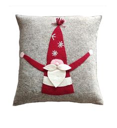 a red and white pillow with a santa clause on it's back, holding his arms out