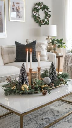 a living room table with candles and christmas decorations on the coffee table in front of it