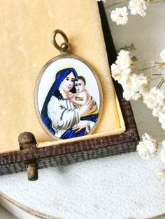 Super beautiful chain pendant made of brass with a hand painted picture of Mary and the Child Jesus. It is completely handmade around 1900-1920. Also a great gift 💙. Total length approx. 3.5 cm Width approx. 2 cm ☀️ shipping is usually done via DHL / Deutsche Post ☀️ photos are part of the descriptions ☀️ please ask any questions before buying :) Antique Enamel Jewelry As Gift, Vintage Hand Painted Pendant Jewelry, Antique Enamel Jewelry As A Gift, Antique Enamel Jewelry For Gift, Vintage Hand Painted Necklace As Gift, Hand Painted Vintage Necklace As Gift, Vintage Hand Painted Necklaces For Gift, Vintage Hand Painted White Jewelry, Vintage White Hand Painted Jewelry