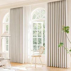 a living room with white furniture and large windows