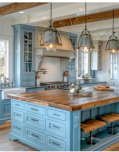 a large kitchen with blue cabinets and wooden counter tops on the island in front of an oven