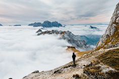 a person standing on top of a mountain above the clouds