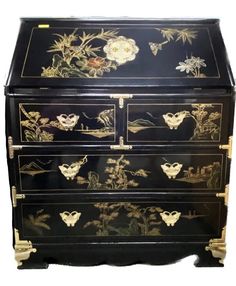 an ornate black and gold chest with flowers on it