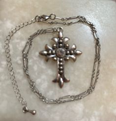 This is a silver-tone cross with a rhinestone in the center. There is no markings as to who made it. The unique-looking chain measures 15" long, plus it has a 3" extension chain. The cross measures 1 3/8" by 1 5/8". In excellent shape. The shipping weight will be 2 ounces. Metal Cross Necklace With Adjustable Chain, Adjustable Chain Metal Cross Necklace, Metal Rhinestone Cross Pendant Necklace, Metal Cross Pendant Necklace With Rhinestones, Metal Cross Necklace With Chain, Metal Cross Necklace With Chain Pendant, Metal Cross Pendant Necklace With Chain, Silver Cross Jewelry With Rhinestones, Silver Cross Metal Jewelry