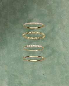 three different types of rings sitting on top of a green surface with one ring in the middle