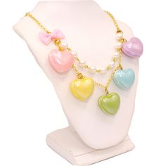 A cute and sweet statement necklace for Valentine's Day or lovecore season! This kawaii charm necklace includes Five heart shaped macaron ( macaroon ) pendants in pastel shades with a pearly finish and whipped cream center. Each necklace includes five 1" (2.5 cm) size charms hanging on a two-layered chain necklace with glass pearls on your choice of a 21" gold plated or silver plated chain. Accented with a baby pink fabric ribbon bow on one side. Necklace will be finished with a Fatally Feminine Multicolor Heart-shaped Kawaii Jewelry, Kawaii Multicolor Heart-shaped Jewelry, Kawaii Necklaces For Valentine's Day, Cute Pastel Jewelry For Gifts, Cute Pastel Jewelry For Gift, Cute Multicolor Heart Charm Necklace, Pastel Kawaii Jewelry Perfect For Gifts, Cute Multicolor Necklaces For Valentine's Day, Kawaii Pastel Jewelry For Gifts