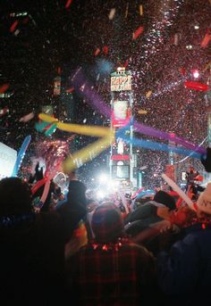 confetti is thrown in the air as people watch at a new year's eve celebration