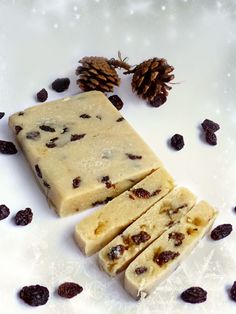 three pieces of soap sitting on top of a white surface next to pine cones and raisins