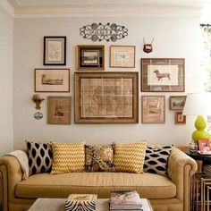 a living room filled with furniture and framed pictures on the wall above it's coffee table