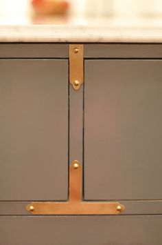 an image of a kitchen cabinet with brass handles