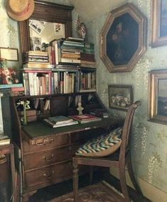 a desk with a chair, bookshelf and pictures on the wall