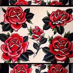 some red roses on white paper with green leaves