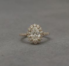 an oval shaped diamond ring with two rows of diamonds around it