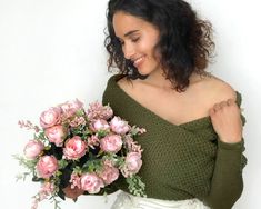 a woman holding a bouquet of pink roses