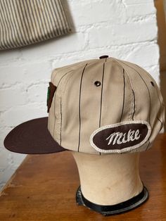 This is a vintage made is USA trucker style hat that I added vintage patches to! Wool 'MPP' patch from the 1940s, and an embroidered 'Mike' workwear name patch. One of a kind. Brown and tan with stripes. In deadstock condition. Adjustable snapback, one size fits most. Gender neutral. All sales are final, so please refer to photos and description. Retro Snapback Hat With Embroidered Logo For Baseball Season, Retro Flat Brim Snapback Hat For Baseball Season, Retro Streetwear Baseball Cap, Retro Snapback Hat With Embroidered Logo, Retro Embroidered Logo Snapback Hat For Streetwear, Retro Trucker Hat With Embroidered Logo, Retro Snapback Baseball Cap For Baseball Season, Vintage 5-panel Trucker Hat For Streetwear, Vintage Adjustable Trucker Hat For Baseball Season