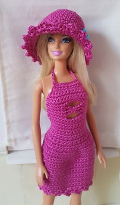 a barbie doll wearing a pink crocheted dress and hat