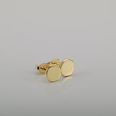 "Shiny round gold 14k stud earrings, simple and perfect for every day's wear.   These gold earrings are handmade of yellow 14k solid gold.  I melted the gold into a ball, and then hammered each ball to its irregular shape. No two are ever identical, and each has a unique and organic look. The edges of the pebbles are rough, while the flat surface has a smooth shiny finish. These are classic \"wear with everything\" gold stud earrings - a perfect gift, or a treat for yourself. Earrings diameter is approx. 7 mm = ~0.27 inch, and they are 1.2 mm thick. 14k solid gold ear backs are included. * The earrings will be packed in a gift box ready to give as a gift, and shipped via Express mail service which usually takes 4-6 business days to arrive. * To see similar earrings in a slightly smaller si 14k Yellow Gold Circle Earrings, Minimalist Round Earrings With Polished Finish, Minimalist Polished Round Earrings, Hypoallergenic Round Earrings In Recycled Gold, Polished Recycled Gold Round Earrings, Dainty Yellow Gold Circular Earrings, Dainty Round Earrings With Polished Finish, Minimalist Hammered Yellow Gold Earrings, Minimalist 14k Gold Round Earrings