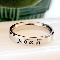 So pretty. This is a 4 mm comfort fit name ring, the most comfortable ring you will ever wear, goes on like silk. It has a brushed finish with shiny rim and flat surface so the letting really stands out.  There is a 15-character limit on this ring.  Names, dates, quotes, scripture or roman numerals.  Stainless steel never tarnishes, changes color, rusts and is hypoallergenic.  Shower and swim safe. Wear 24/7 I hand stamp each letter, then use the best quality jewelry paint, clean and polish.  I Simple Adjustable Personalized Rings, Adjustable Hypoallergenic Promise Engraved Ring, Simple Adjustable Personalized Ring, Meaningful Stackable Promise Rings, Personalized Engraved Promise Ring With Round Band, Adjustable Hypoallergenic Promise Ring, Stainless Steel Stackable Promise Ring, Personalized Initial Ring For Promise With Round Band, Personalized Initial Ring For Promise Occasions