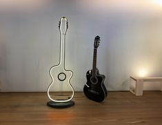 an acoustic guitar is next to a modern sculpture